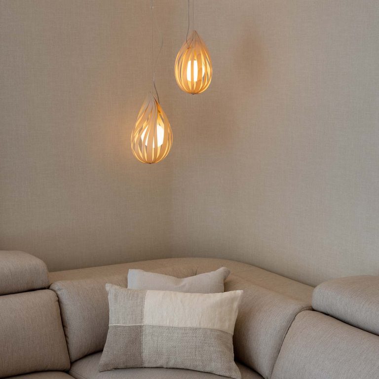 detalle de sofa con curva y la lampara suspendida drop de la marca luzifer